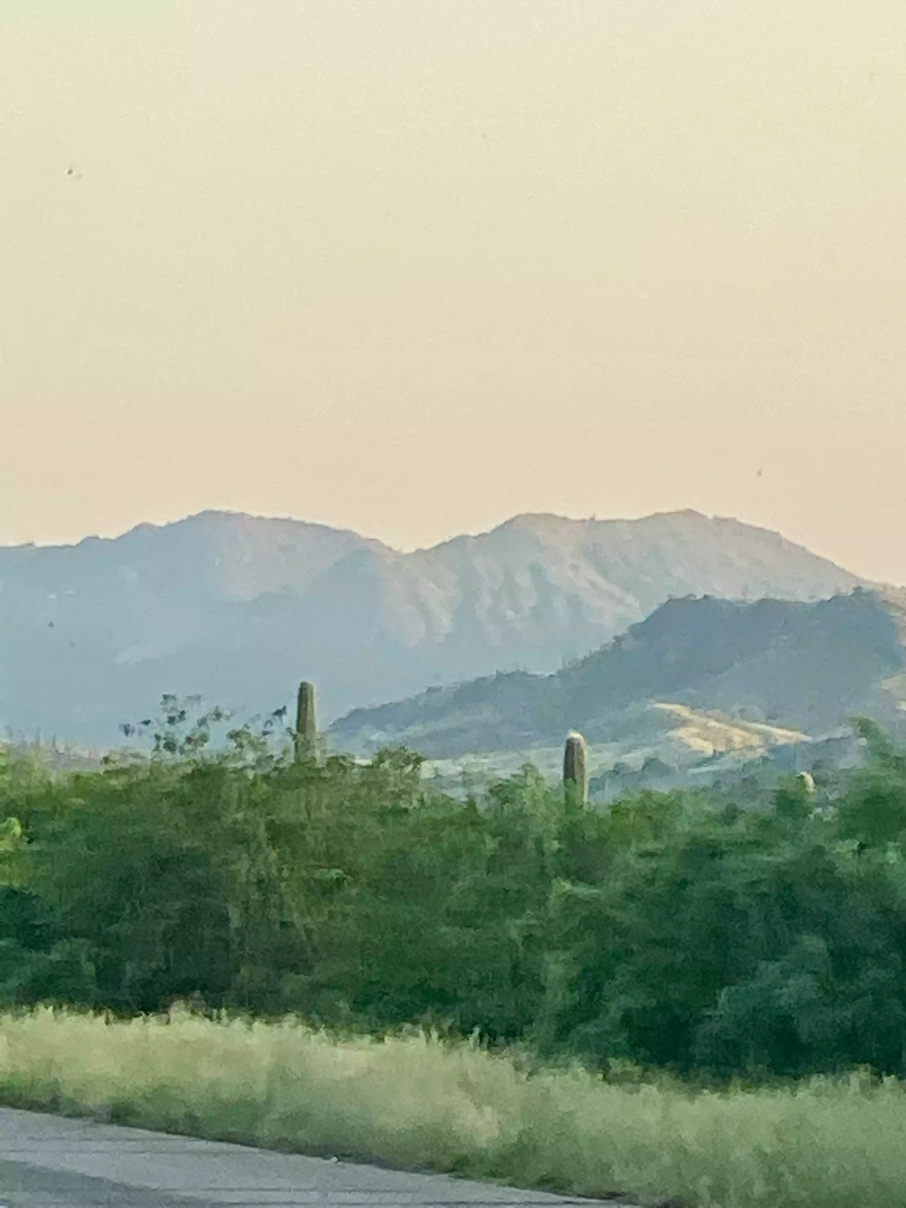 A car driving down a road with mountains in the background